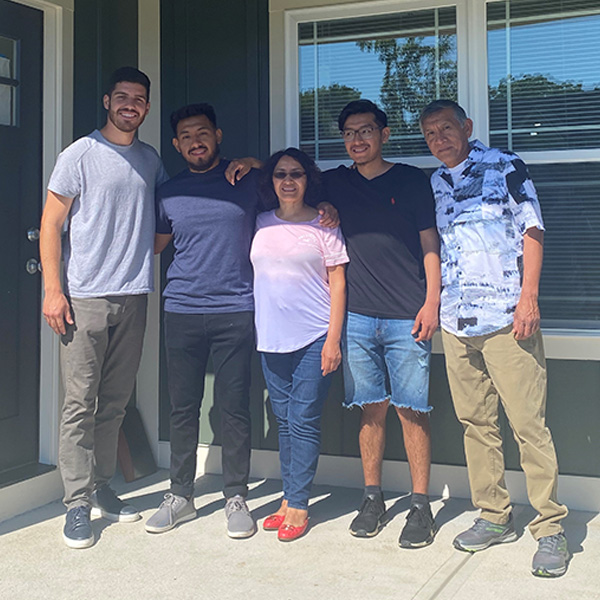 Fabio-with-Family-and-Realtor-at-home Fabio with family outside new home
